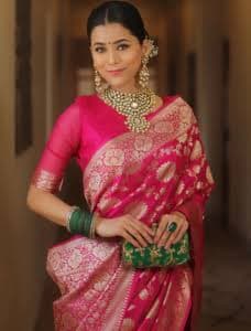 Model in a rani-pink banarasi saree with gold zari