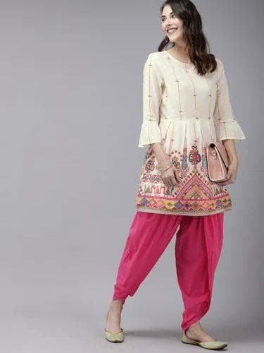 Model in a cream printed kurti with a pink salwar